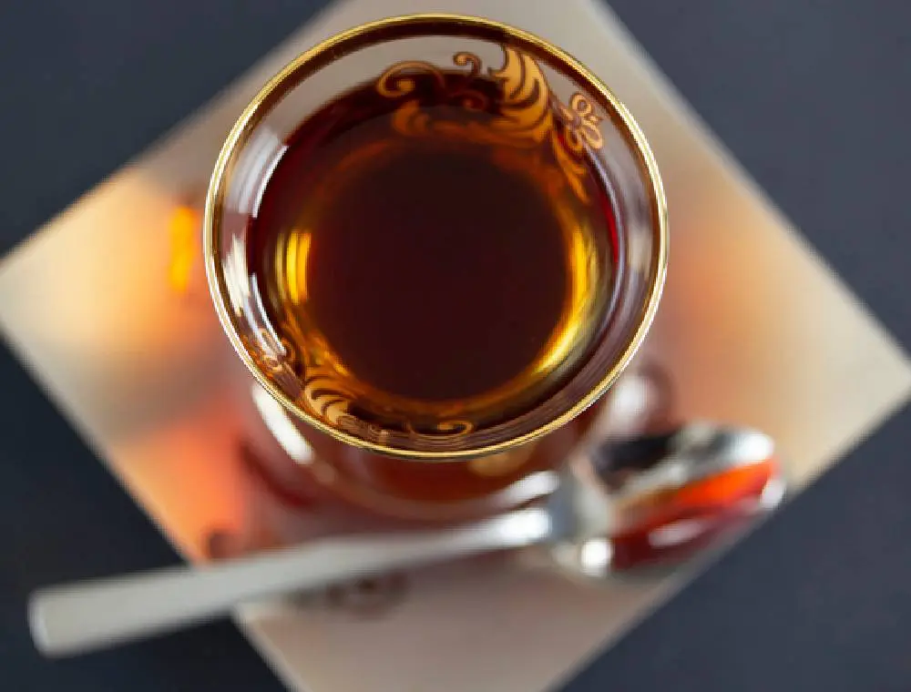 Ornate glass cup of tea with spoon