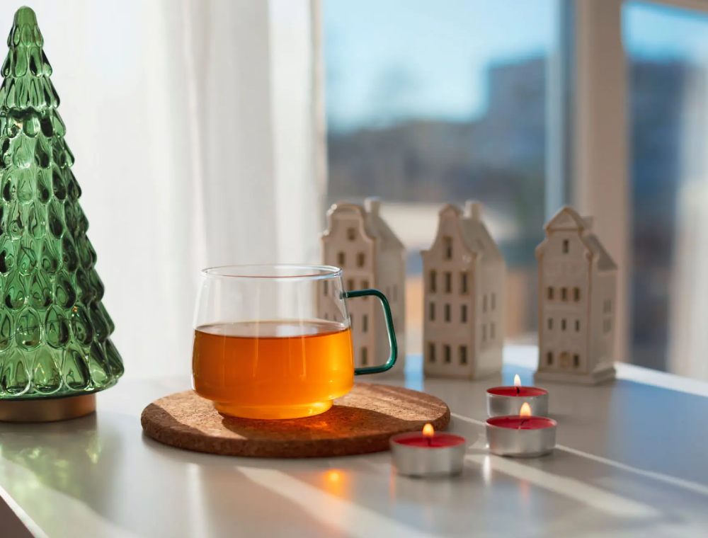 Cozy holiday tea scene with candles and ornaments